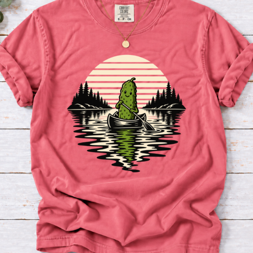 Canoeing pickle under a retro sunset on a watermelon T-shirt.