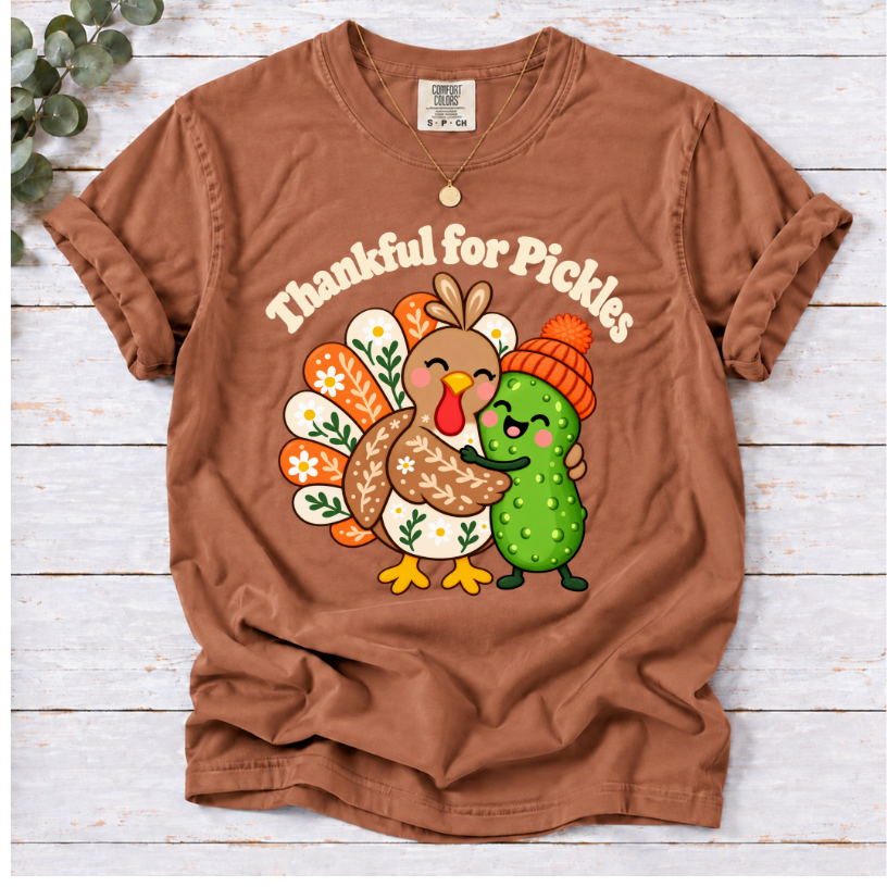 yam Thankful for Pickles T-shirt featuring a cartoon turkey hugging a green pickle wearing an orange knit hat.”