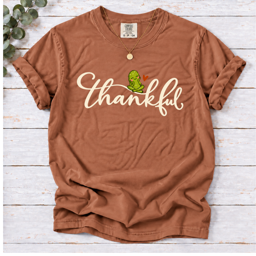 Yam T-shirt with thankful script, a smiling green pickle, and a small orange heart.